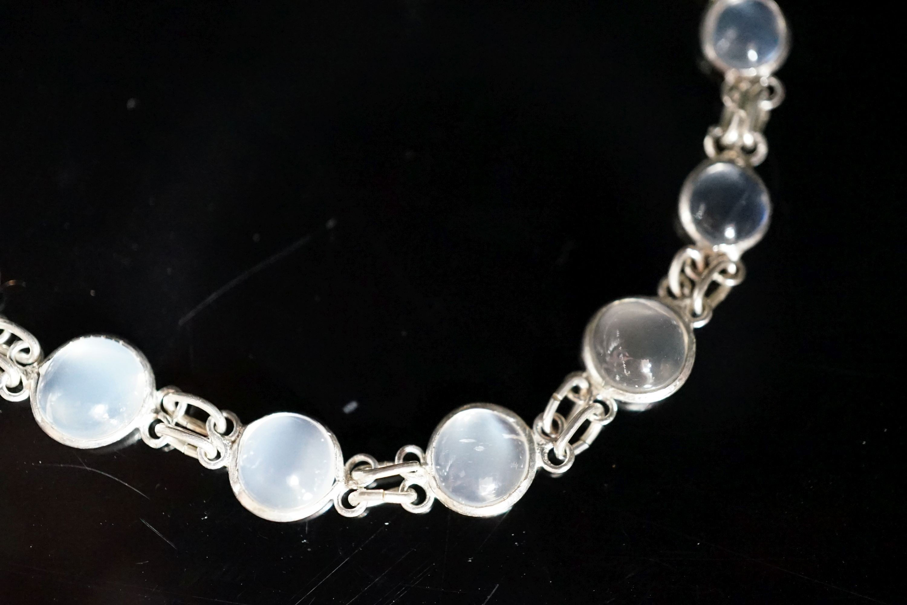 A modern (1980's) white metal and graduated moonstone set bracelet, 17cm.